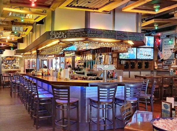 The interior of Geddy’s in Bar Harbor Maine with its famous iconic bar, a popular spot for music legends and locals.