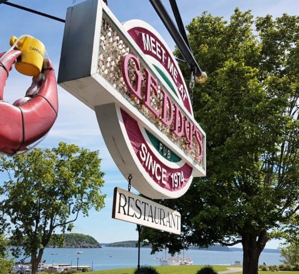 For fresh seafood, Geddy's Bar Harbor restaurant for the best seafood in Bar Harbor, Maine, showing signage with water view.