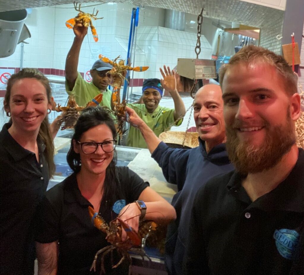 Geddy's Crew holding Maine lobsters from the live lobster tank in downtown Bar Harbor