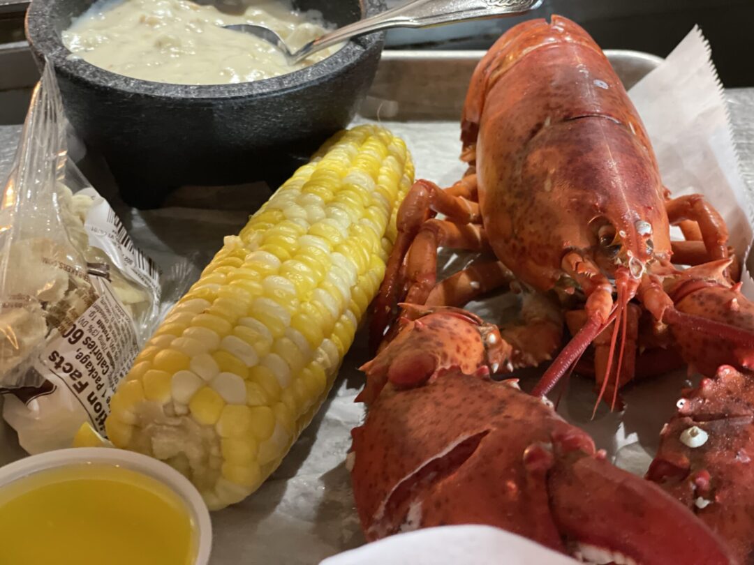 Classic Maine lobster bake with steamed lobster, corn on the cob, clam chowder, and blueberry pie at Geddy's in Bar Harbor