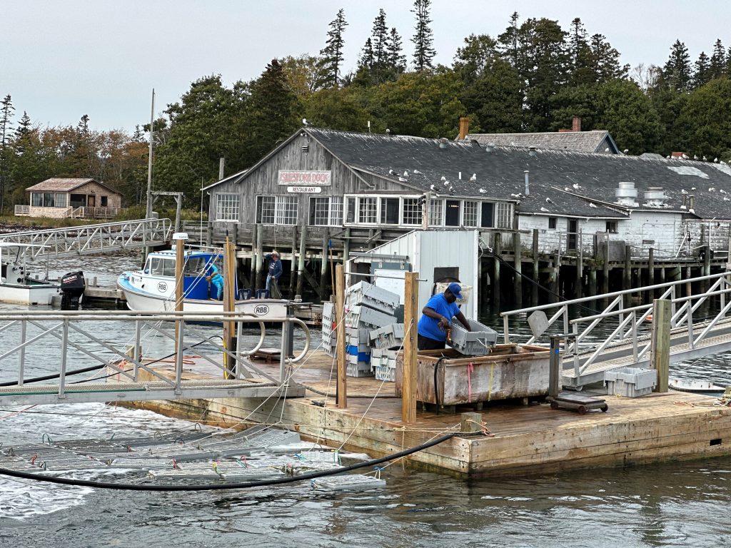 Islesford Dock Restaurant on Little Cranberry Island, Maine with lobster boats and working docks along the waterfront.