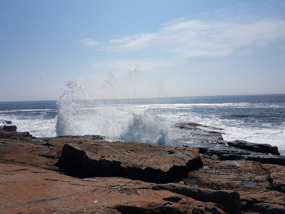 Waves crashing against the rocky coastline at Thunder Hole in Acadia National Park, Maine.