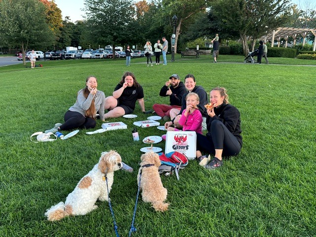 Family enjoying Geddy's takeout with their dogs at Agamont Park, overlooking the waterfront, in downtown Bar Harbor, Maine